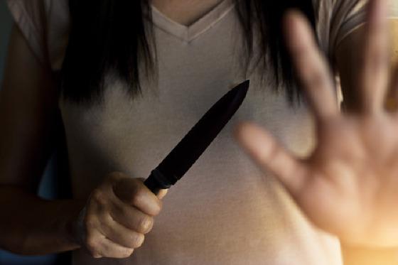 70722427-mulher-segurando-uma-faca-na-mão-enquanto-se-defende-de-ataques.jpg